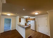 Thumbnail 6 of 15 - A kitchen with a refrigerator, cabinets, and a countertop.