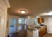 Thumbnail 5 of 15 - A kitchen with a sink, microwave, and cabinets.