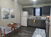 Thumbnail 4 of 15 - a kitchen with a refrigerator and a sink and a table and chairs