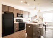 Thumbnail 8 of 8 - A modern kitchen with dark brown cabinets and appliances.