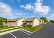 Thumbnail 26 of 33 - A street view of a residential area with houses on both sides and a clear blue sky.