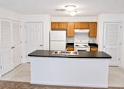 Thumbnail 15 of 20 - A kitchen with white appliances and wooden cabinets.