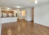 Thumbnail 12 of 17 - A spacious living room with hardwood floors and a ceiling fan.