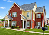 Thumbnail 1 of 20 - A red brick house with a white roof and a mailbox in front.
