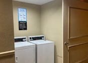 Thumbnail 34 of 43 - A sign is on the wall above the washing machine.