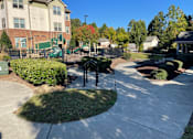 Thumbnail 3 of 5 - a sidewalk in front of a building with a playground