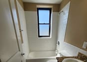 Thumbnail 35 of 43 - A bathroom with a toilet, sink, and bathtub.