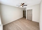 Thumbnail 8 of 9 - A room with a ceiling fan and a door.