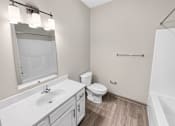 Thumbnail 9 of 9 - A white bathroom with a toilet, sink, and mirror.