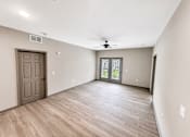 Thumbnail 7 of 9 - A room with a wooden floor and a ceiling fan.