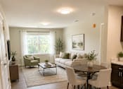 Thumbnail 8 of 12 - A living room with a couch, chairs, and a coffee table.
