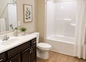 Thumbnail 10 of 12 - A bathroom with a toilet, sink, and shower.