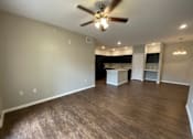 Thumbnail 17 of 23 - A room with a ceiling fan and wooden flooring.