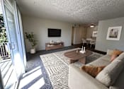 Thumbnail 11 of 18 - A living room with a grey couch and a coffee table.