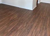 Thumbnail 12 of 16 - A room with wooden flooring and white walls.