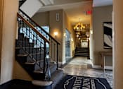 Thumbnail 1 of 43 - A lobby with a staircase and a sign that says Starbucks