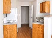 Thumbnail 8 of 14 - A kitchen with wooden cabinets and a white fridge.