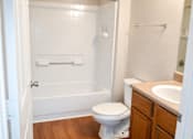 Thumbnail 10 of 14 - A white toilet sits in a bathroom next to a sink.