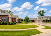Thumbnail 7 of 14 - A suburban neighborhood with houses and well-maintained lawns.