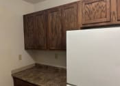 Thumbnail 7 of 8 - a kitchen with a white refrigerator and wooden cabinets