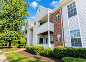 Thumbnail 17 of 18 - A white two-story apartment building with a red brick chimney.