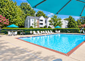 Thumbnail 5 of 37 - A swimming pool surrounded by lounge chairs and umbrellas.
