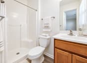 Thumbnail 23 of 37 - A white toilet sits next to a white sink in a bathroom.