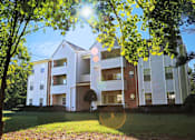 Thumbnail 1 of 20 - A modern apartment building with a white facade and multiple balconies.