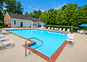 Thumbnail 2 of 18 - A pool with a red brick border and a diving board.
