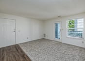 Thumbnail 8 of 20 - A room with a carpeted floor and a window with blinds.
