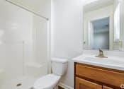 Thumbnail 9 of 20 - A white toilet sits next to a white sink in a bathroom.