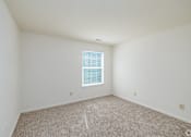 Thumbnail 10 of 20 - A room with a window and carpeted floor.