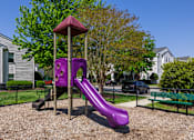 Thumbnail 12 of 20 - A purple slide in a playground with a red roof.