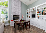 Thumbnail 16 of 20 - A living room with a fireplace and a dining table.