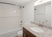 Thumbnail 6 of 14 - A white bathroom with a sink, toilet, and bathtub.at Mammoth at the Orchard Apartments, Arkansas  