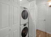Thumbnail 8 of 14 - A white washing machine and dryer in a laundry room.at Mammoth at the Orchard Apartments, Rogers, AR 72756  