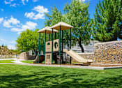 Thumbnail 4 of 9 - A playground with a slide and a swing set.