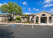Thumbnail 9 of 9 - A parking lot in front of a building with a palm tree.