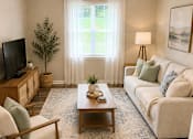Thumbnail 10 of 15 - A living room with a white couch, a wooden coffee table, and a flat screen TV.