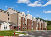 Thumbnail 2 of 15 - A large apartment complex with a fire hydrant in front of it.