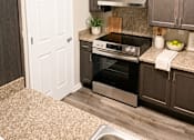 Thumbnail 14 of 15 - A kitchen with a stove top oven and a white door.