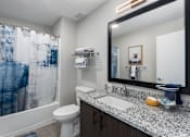 Thumbnail 13 of 17 - A bathroom with a toilet, sink, and shower curtain.