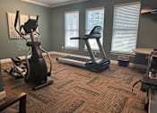 Thumbnail 4 of 18 - a home gym with exercise equipment and three windows