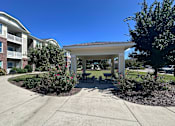 Thumbnail 2 of 18 - a pavilion with a seating area in front of an apartment building