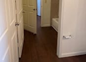 Thumbnail 11 of 26 - A hallway with white doors and a white wall.
