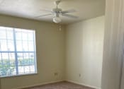 Thumbnail 16 of 26 - A room with a ceiling fan and carpeted floor.