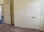 Thumbnail 22 of 26 - A room with two white doors and a ceiling fan.