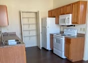 Thumbnail 13 of 26 - A kitchen with wooden cabinets and a white refrigerator.