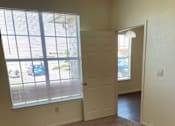 Thumbnail 10 of 26 - A room with a carpeted floor and a door leading to another room.