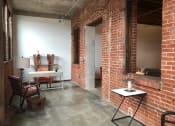 Thumbnail 26 of 34 - a living room with a brick wall and a table